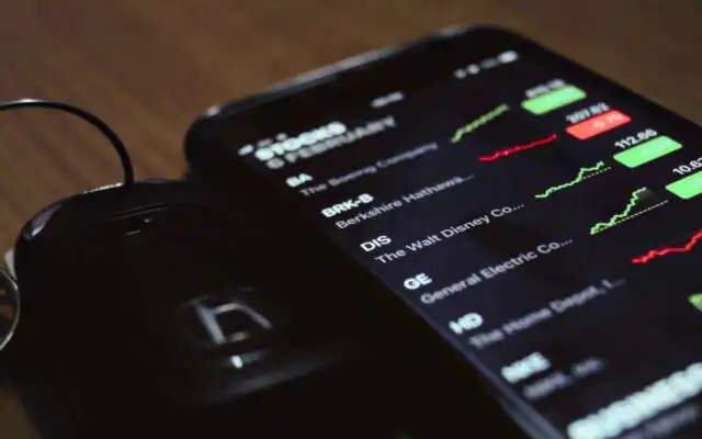 The Stocks app is open on an iPhone that is resting on a table.